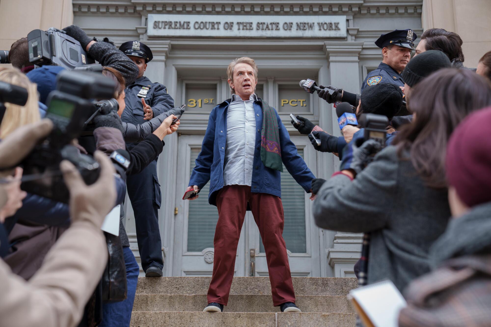 A man exits a courthouse to find a mob of reporters in a scene from "Only Murders in the Building."