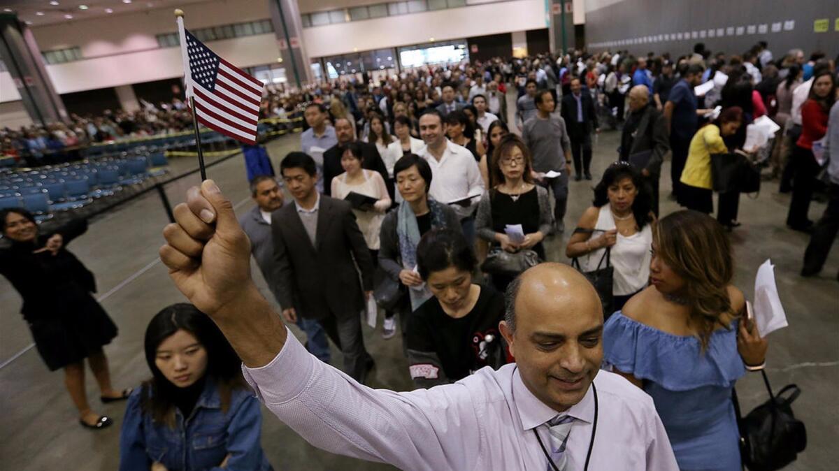 Munir Nizami, a U.S. Citizenship and Immigration Services assistant, leads future citizens and family members into a naturalization ceremony.