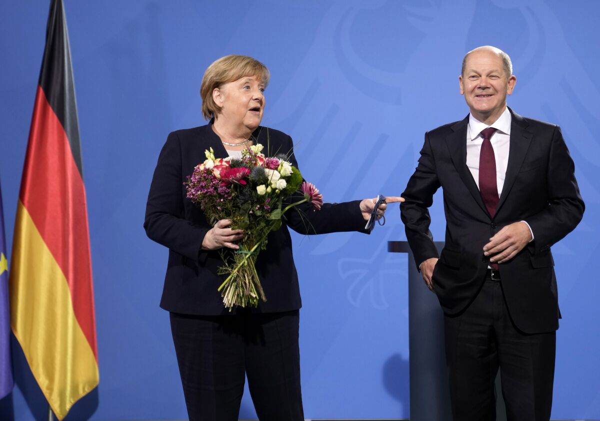 New elected German Chancellor Olaf Scholz, right, has given flowers to former Chancellor Angela Merkel during a handover ceremony in the chancellery in Berlin, Wednesday, Dec. 8, 2021. (Photo/Markus Schreiber)
