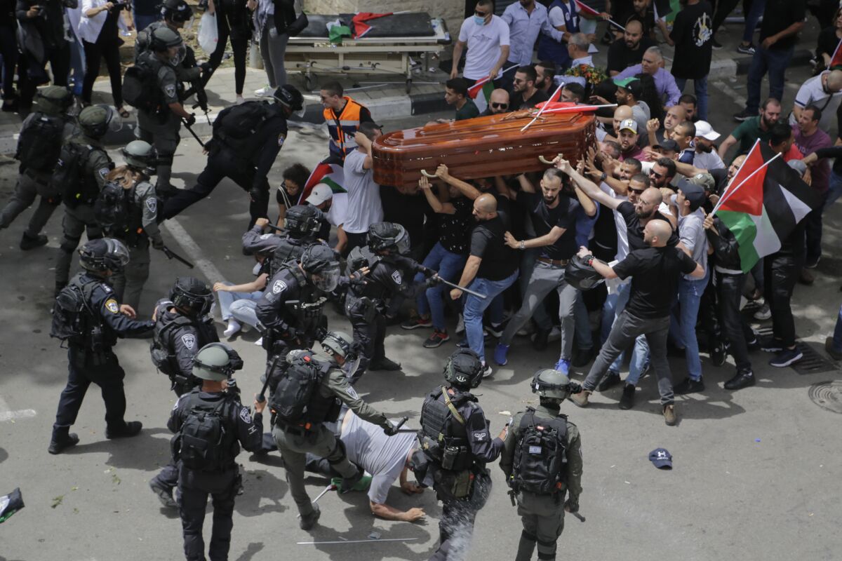 FILE - Israeli police confront with mourners as they carry the casket of slain Al Jazeera veteran journalist Shireen Abu Akleh during her funeral in east Jerusalem, Friday, May 13, 2022. An Israeli police investigation reveals that police engaged in misconduct during the funeral of Abu Akleh. Those who supervised the event will not face serious punishment, according to an Israeli daily newspaper report published on Thursday, June 16, 2022. (AP Photo/Maya Levin, File)