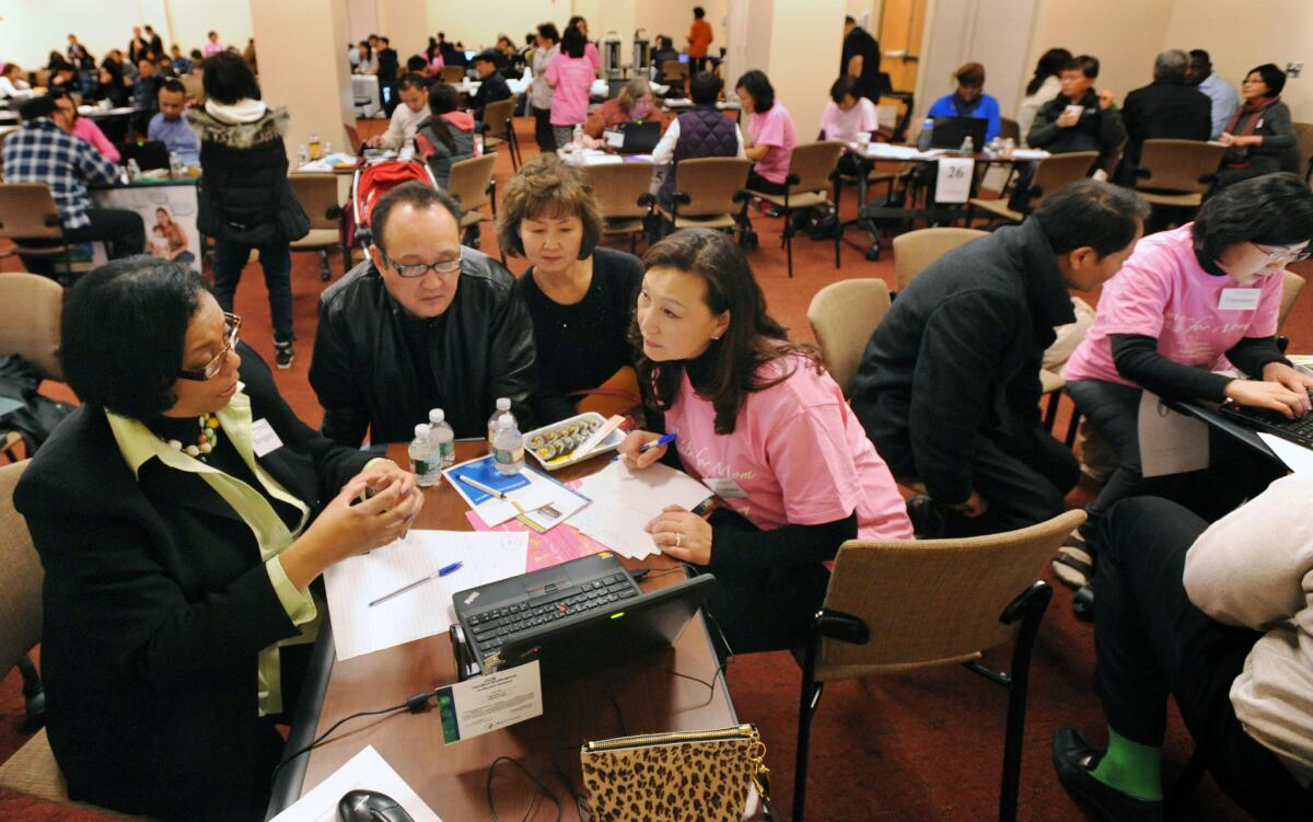 Counselors help Korean Americans sign up for health insurance during an event at Holy Name Medical Center in Teaneck, N.J., this month.