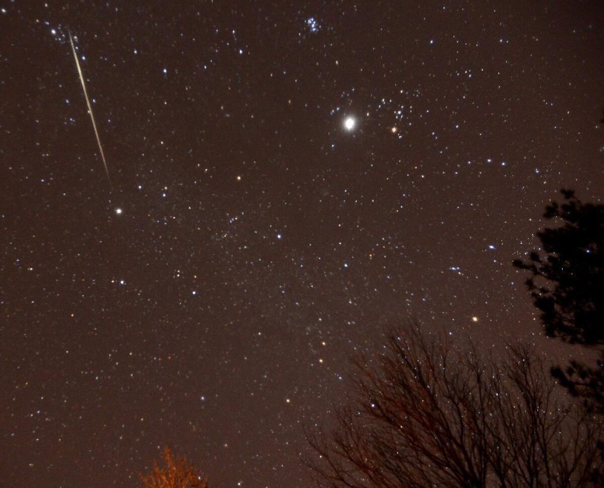 A meteor streaks across the sky during the annual Geminid meteor shower over Springville, Ala.