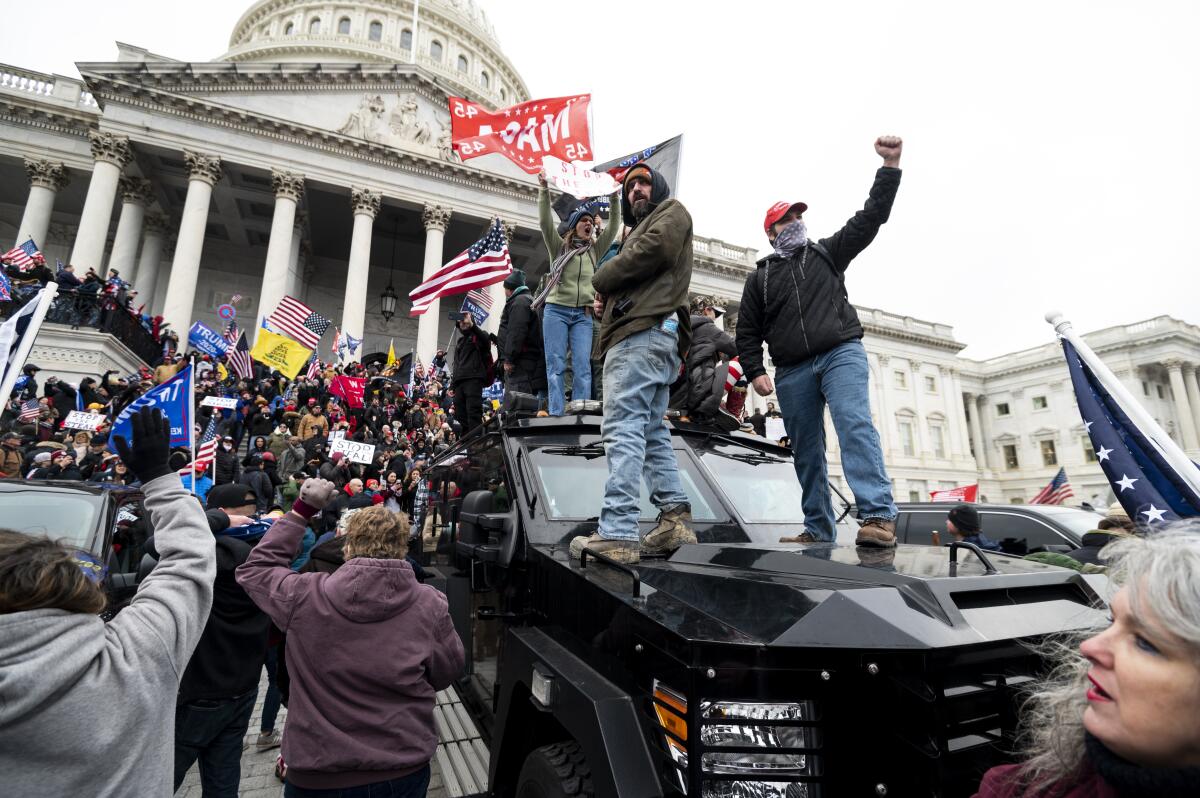 Trump supporters stand on a Capitol Police armored vehicle outside the Capitol on Wednesday