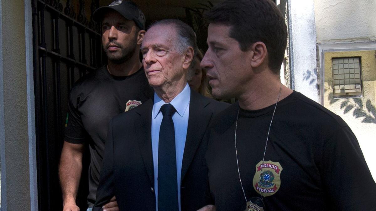 Carlos Nuzman, president of Brazil's Olympic committee, center, is escorted by federal police officers after being taken into custody at his home in Rio de Janeiro on Oct. 5.