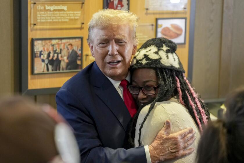 El expresidente Donald Trump (izq) abraza a Michaelah Montgomery, una activista local de derechas, en un restaurante Chick-fil-A en Atlanta, el 10 de abril de 2024. (Foto AP/Jason Allen)