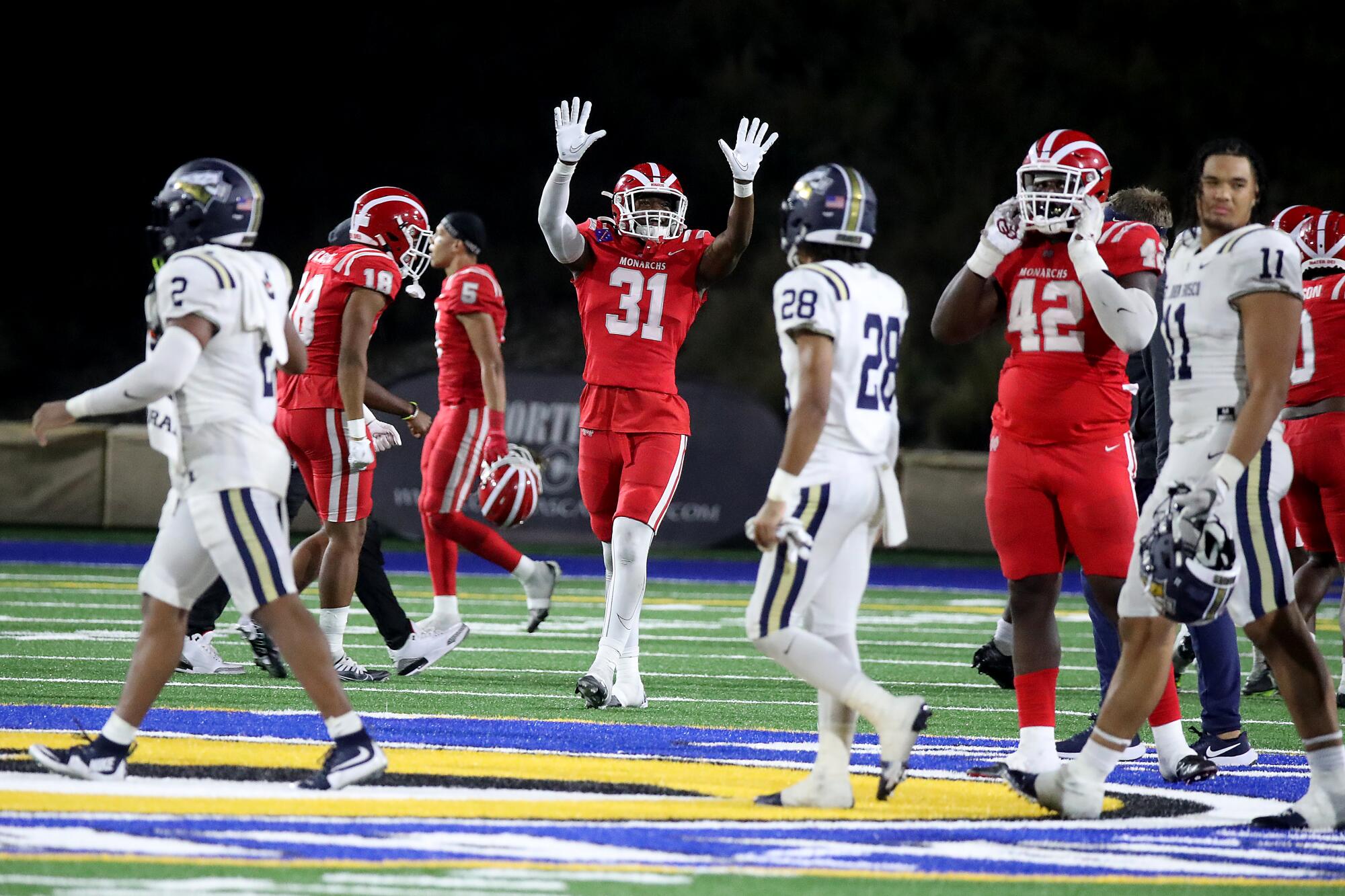 A Mater Dei player celebrates after the game with hands raised
