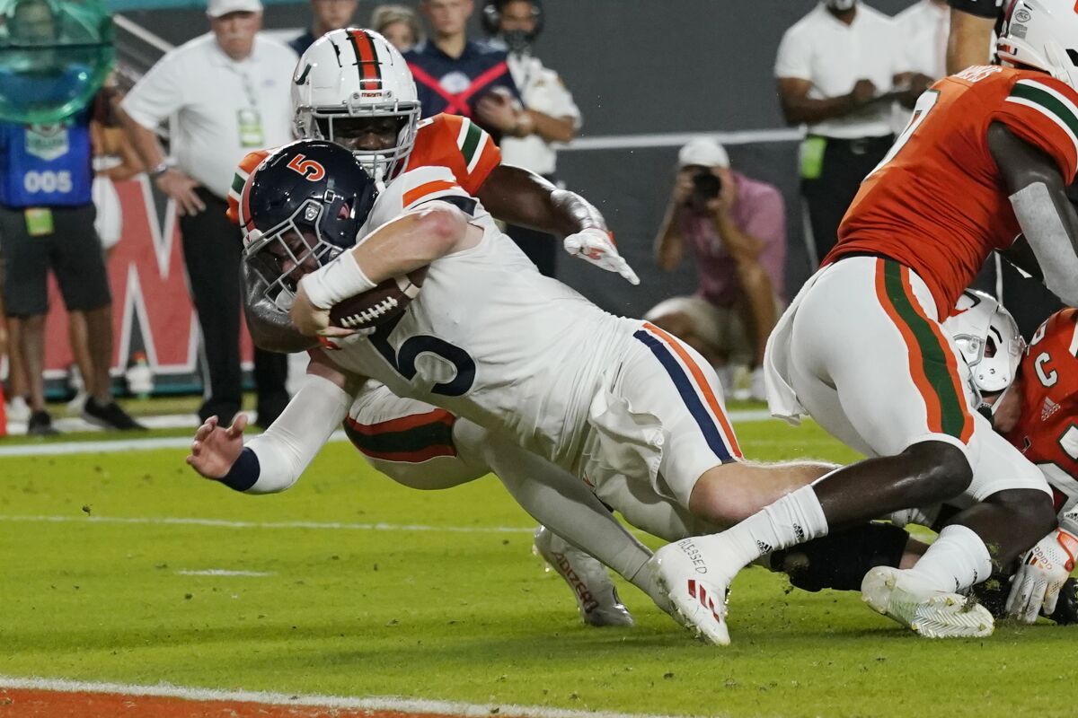 Virginia Cavaliers quarterback Brennan Armstrong (5) is tackled by Miami Hurricanes cornerback Tyrique Stevenson close to the end zone during the first half of a NCAA college football game, Thursday, Sept. 30, 2021, in Miami Gardens, Fla. (AP Photo/Lynne Sladky)