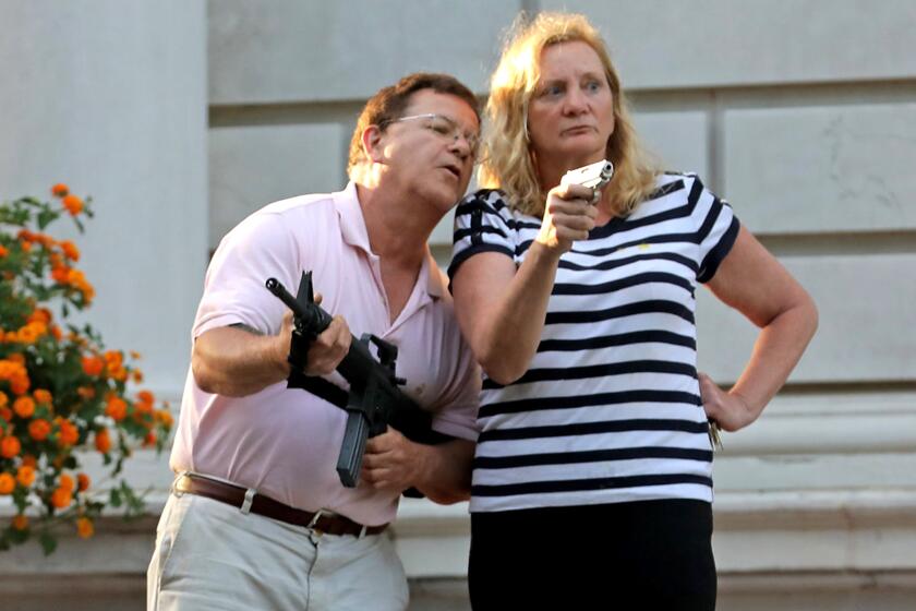 FILE - In this June 28, 2020 file photo, Mark and Patricia McCloskey emerged from their St. Louis mansion with guns after protesters walked onto their private street. The couple, who were criminally charged for the incident, will make the case in a recorded message Monday night, Aug. 24 in their opening night speech of the Republican National Convention that they had a “God-given right” to defend themselves and their property. (Laurie Skrivan/St. Louis Post-Dispatch via AP, File)