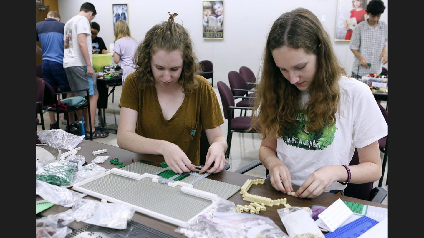 Sisters Caleigh Paster, 17, and Maya Paster, 14, work together to create the Griffith Park Observatory at Burbank Central Library's Legotopia, in Burbank on Friday, July 14, 2017. The event was open to teens im seventh through 12th grade.