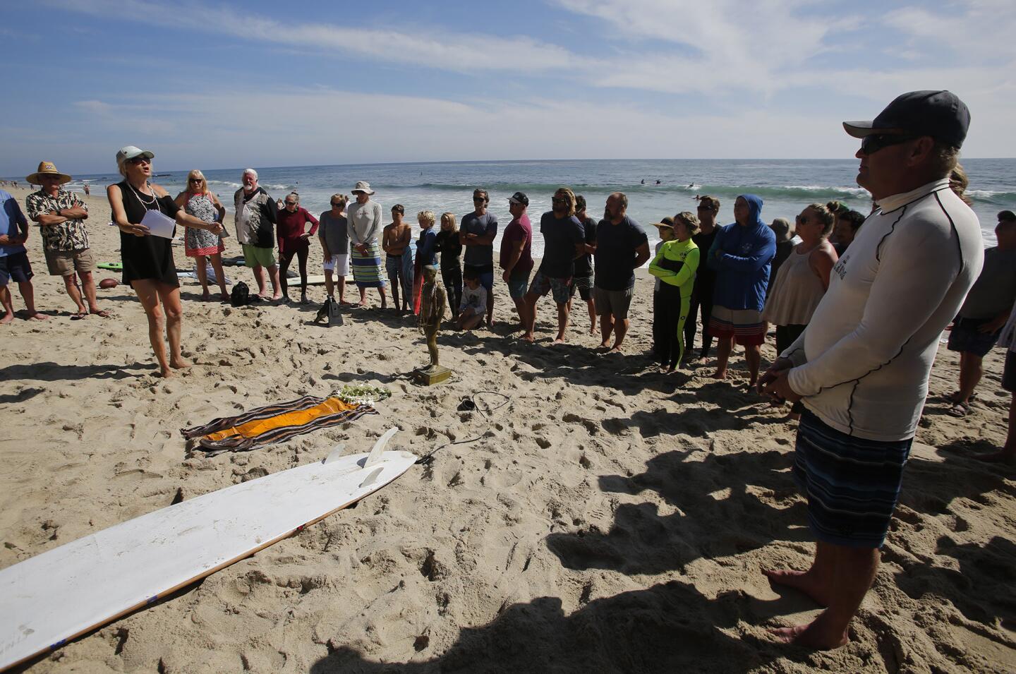 Christy Cones, left, speaks at a memorial ceremony for longtime Laguna Beach resident and International Swimming Hall of Fame inductee Bruce Hopping at Thalia Street Beach on Thursday.