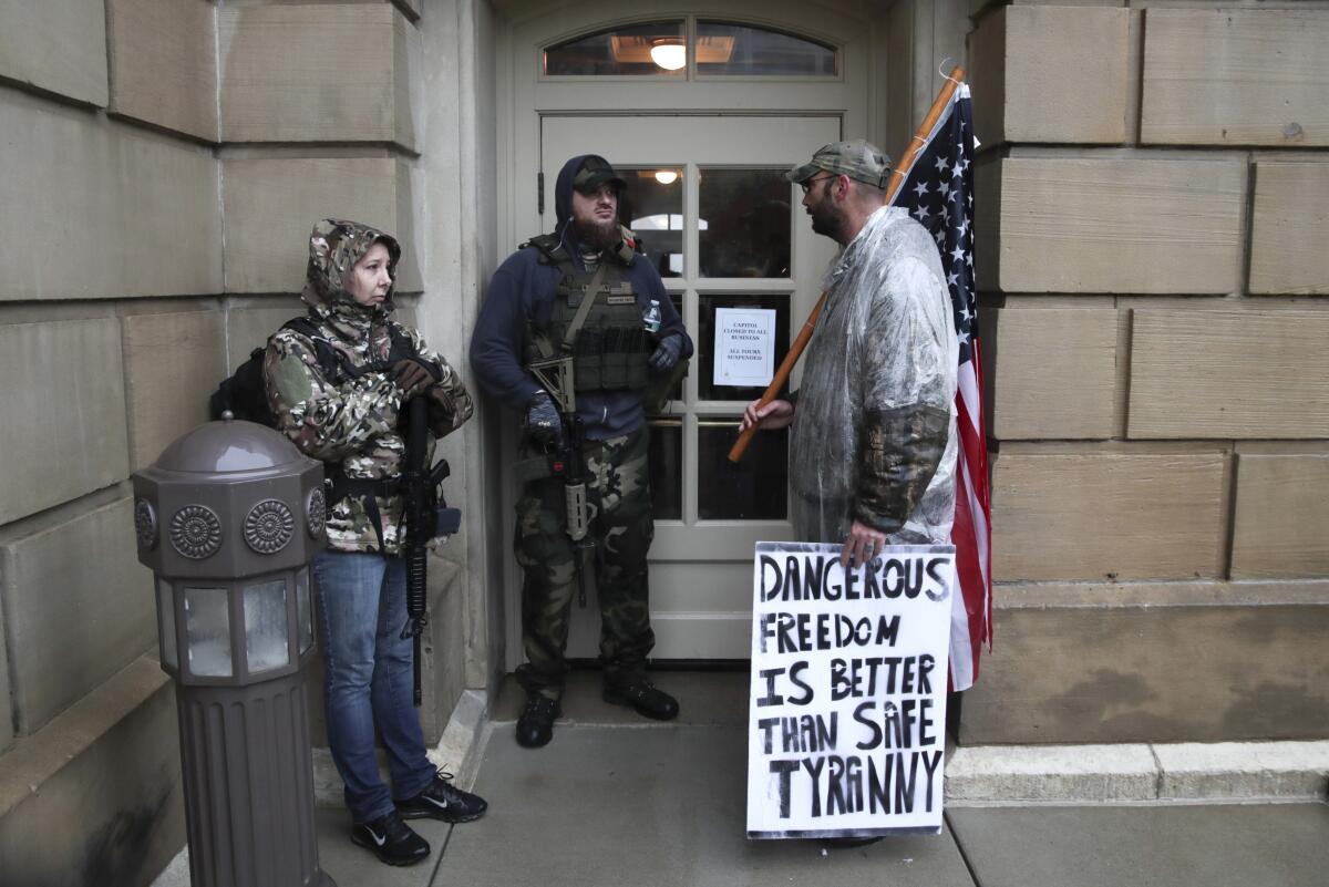 Protesters with rifles demonstrate Thursday at Michigan's Capitol against the governor's stay-at-home order.