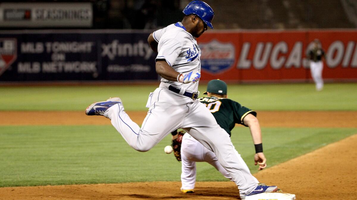 Dodgers right fielder Yasiel Puig beats a throw to first base during a game against Oakland on Tuesday. He injured his right hamstring on the play and left the game.