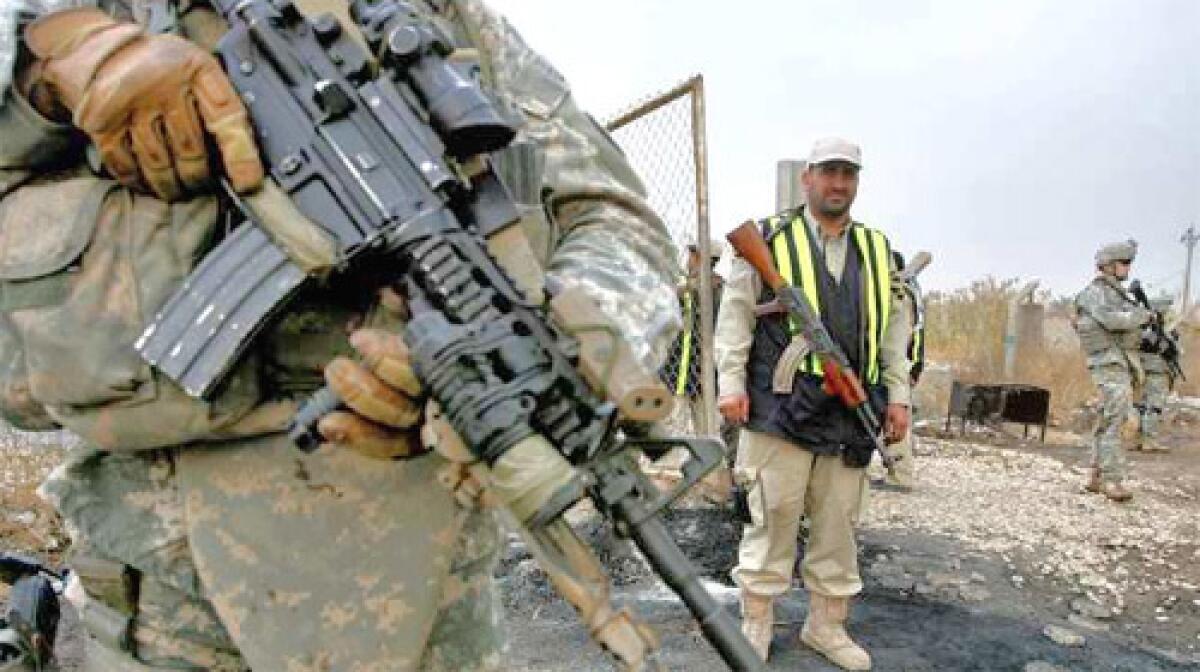 A member of the Concerned Local Citizen (CLC), center, watches as U.S. soldiers from the 2nd Squadron, 2nd Stryker Cavalry Regiment, secure an area during a patrol in Baghdad.
