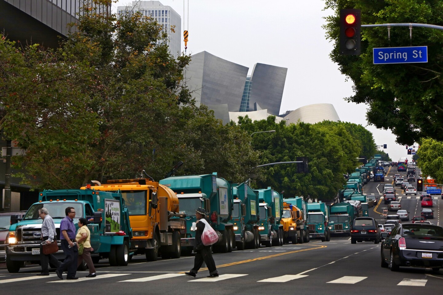 A line of garbage trucks on 1st Street headed to join hundreds of city workers and their allies outside Los Angeles City Hall on Tuesday morning, protesting "predatory fees" the city pays to Wall Street banks.