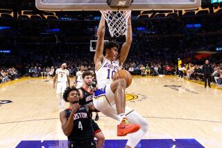Lakers guard Max Christie dunks over Houston Rockets guard Jalen Green during the first half at Crypto.com Arena.