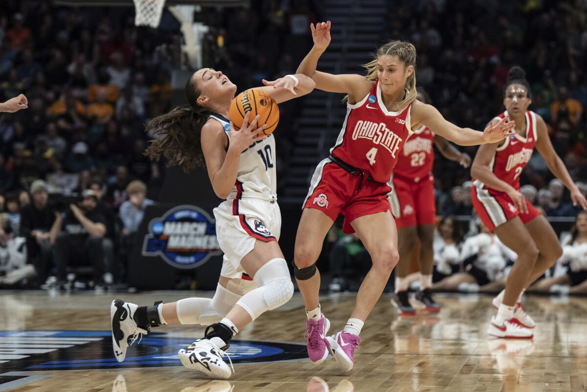 UConn guard Nika Muhl (10) collides with Ohio State guard Jacy Sheldon while trying to beat a full court press during the second half of a Sweet 16 college basketball game of the NCAA tournament, Saturday, March 25, 2023, in Seattle. (AP Photo/Stephen Brashear)