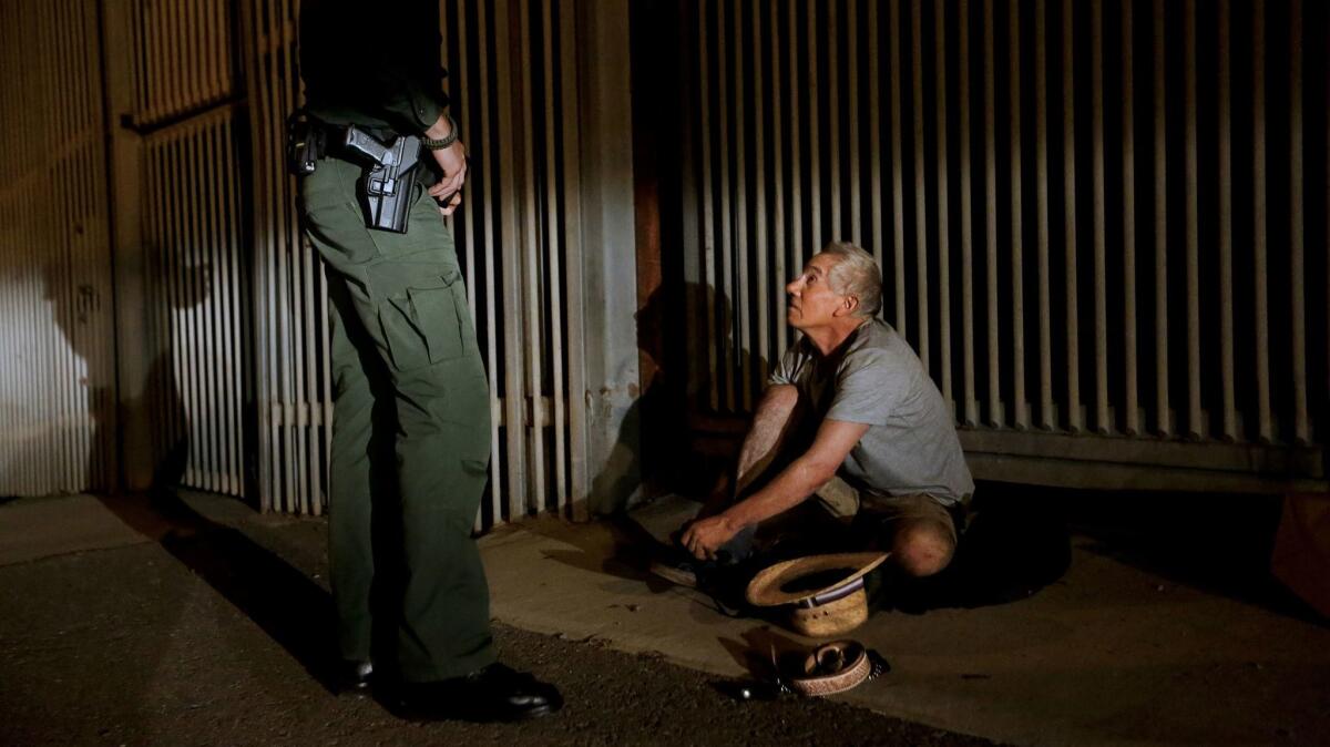 U.S. Border Patrol agent Eduardo Olmos, 38, apprehends a 54-year-old man from Guerrero, Mexico, who had been trying to climb the secondary fence at Border Field State Park into San Diego from Tijuana.