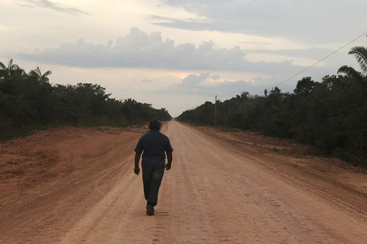A man walks on a dirt road