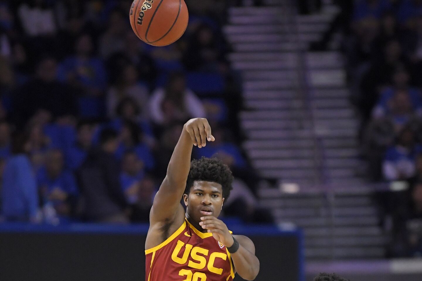 USC guard Ethan Anderson passes the ball over UCLA guards Tyger Campbell (10) and Chris Smith (5) during a game Jan. 11 at Pauley Pavilion.
