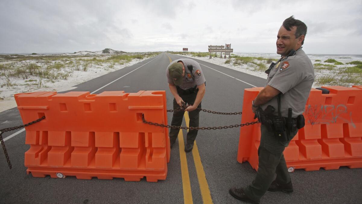 Rangers with the National Park Service close off Highway 399 through Gulf Islands National Seashore as a subtropical storm makes landfall on Monday.