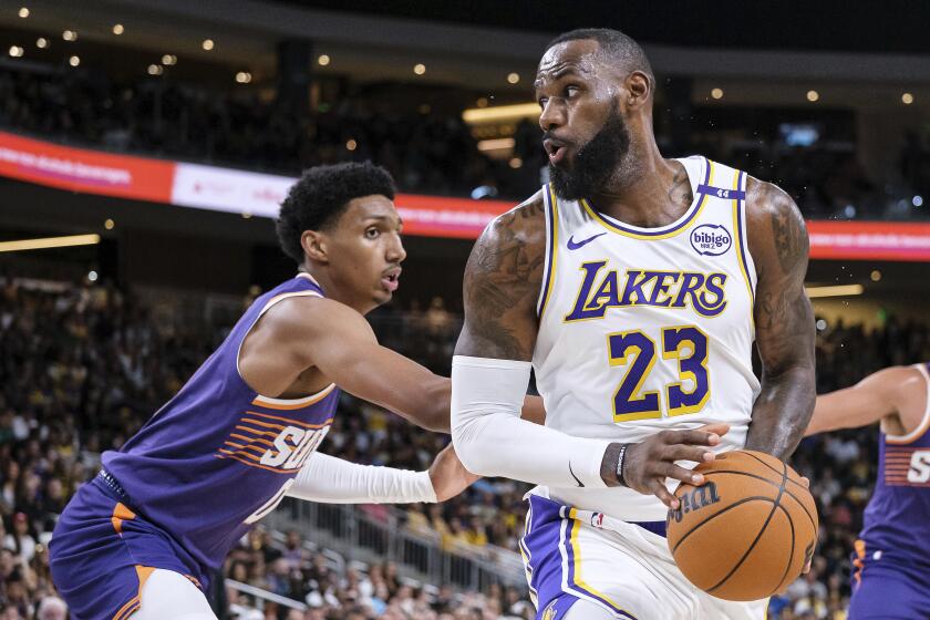 Los Angeles Lakers forward LeBron James (23) looks to drive to the basket while under pressure from Phoenix Suns forward Ryan Dunn (0) during the first half of a preseason NBA basketball game Sunday, Oct. 6, 2024, in Palm Desert, Calif. (AP Photo/William Liang)