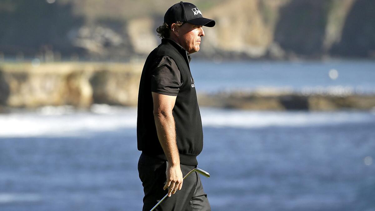 Phil Mickelson looks out at the ocean after missing a birdie putt on the 18th green Sunday at Pebble Beach.