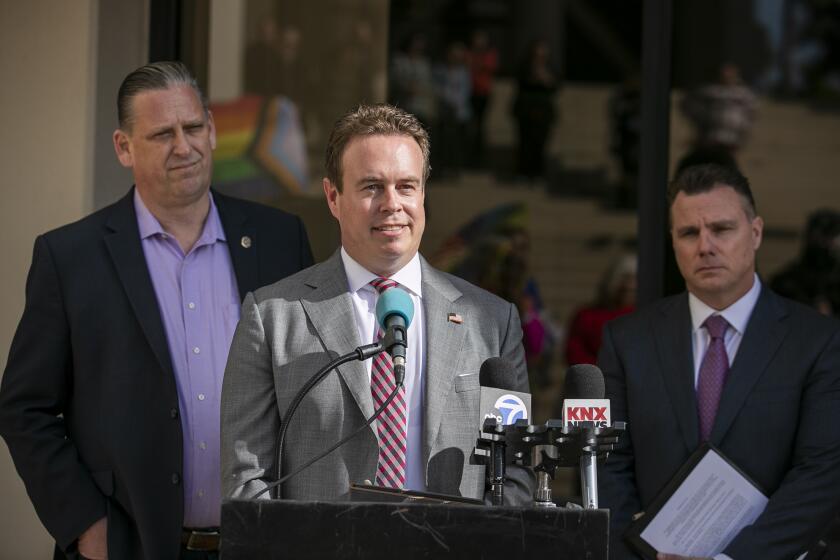 Huntington Beach, CA - February 14: Huntington Beach City Council member Casey McKeon, center, flanked by Mayor Tony Strickland and City Attorney Michael Gates, speaks during a press conference to discuss the city's battle with the state of California over housing laws on Tuesday, Feb. 14, 2023 in Huntington Beach, CA. (Scott Smeltzer / Daily Pilot)