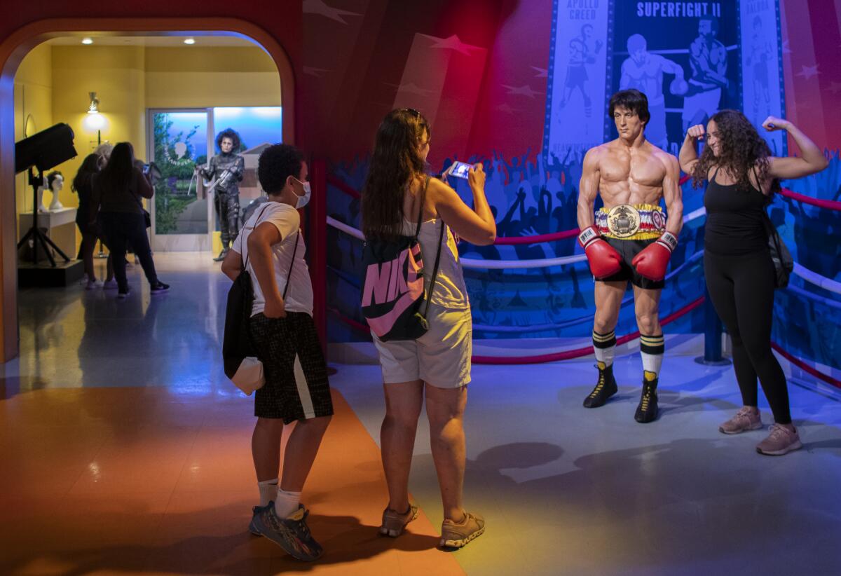A tourist poses next to a wax figure.