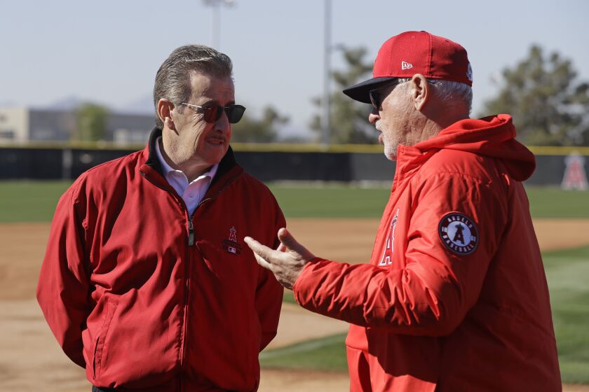 Los Angeles Angels manager Joe Maddon, right, talks with Los Angeles Angels owner Arte Moreno during spring training baseball practice, Wednesday, Feb. 12, 2020, in Tempe, Ariz. (AP Photo/Darron Cummings)