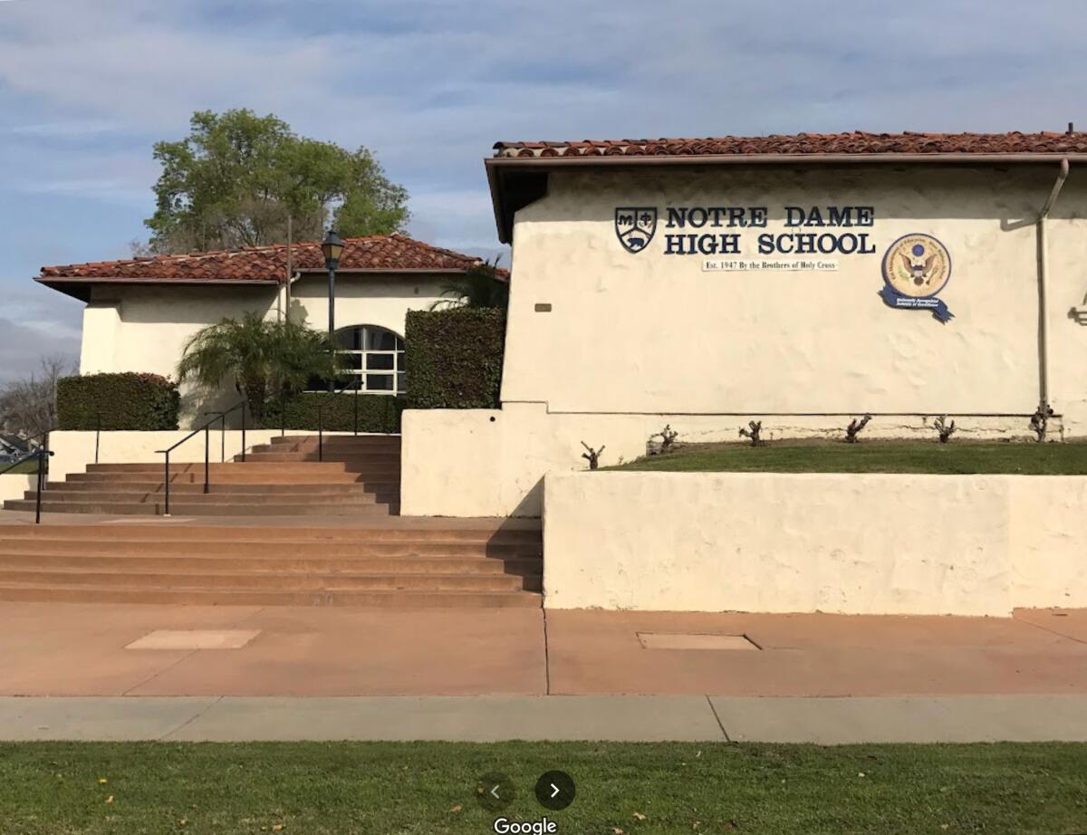 A cream-colored building with the words Notre Dame High School 