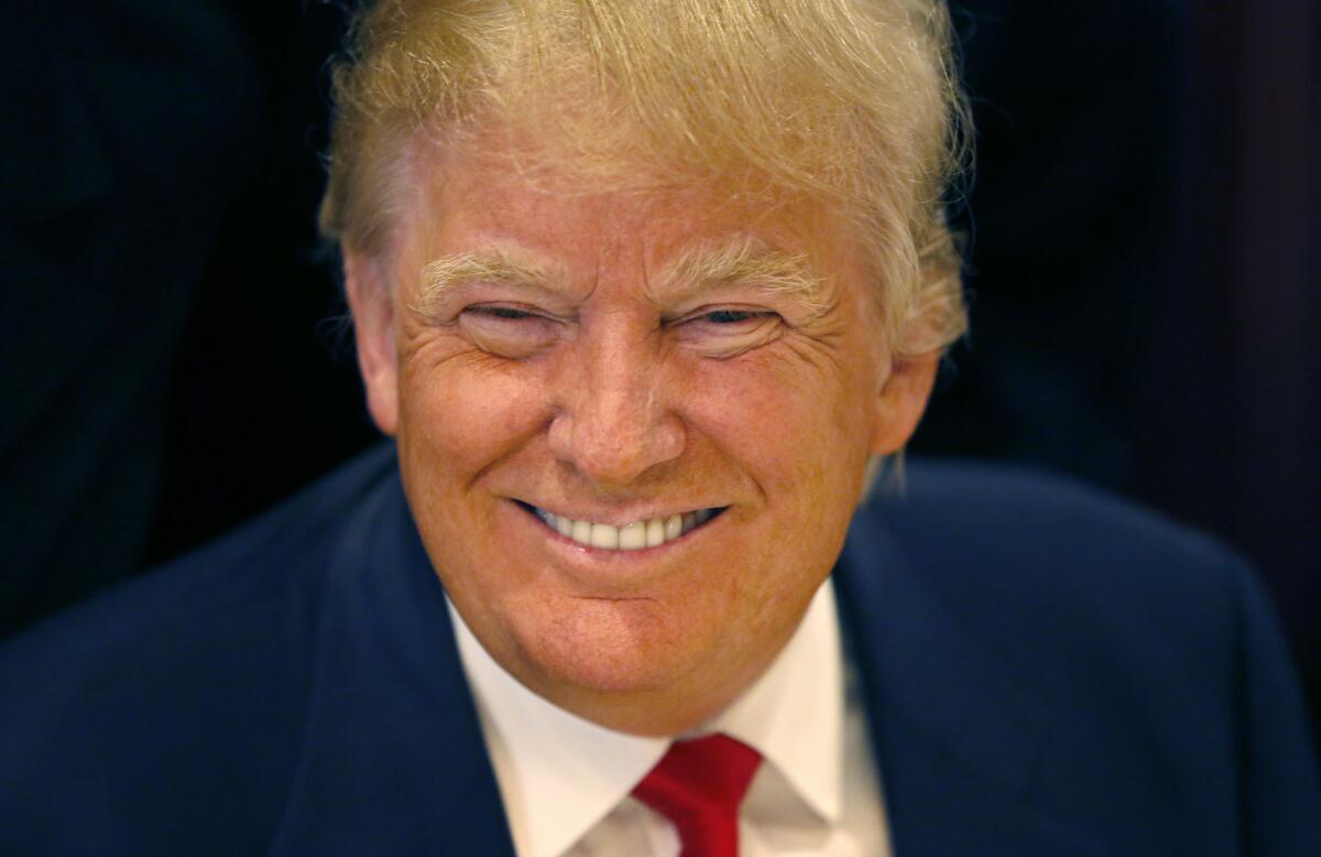 Republican presidential candidate Donald Trump smiles for a photographer before he addresses members of the City Club of Chicago, Monday, June 29, 2015, in Chicago. (AP Photo/Charles Rex Arbogast)