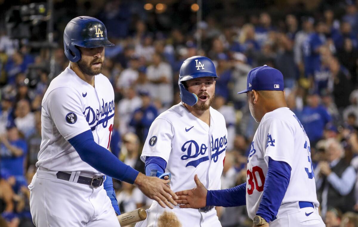 Dodgers' Joey Gallo celebrates with Gavin Lux and manager Dave Roberts after scoring on a home run by Chris Taylor.