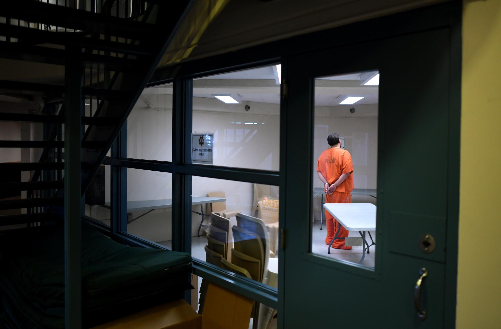 An inmate is handcuffed in a holding cell at the main jail in downtown Sacramento.