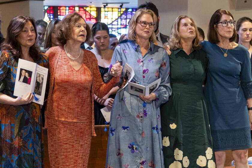 Adele Graham, wife of U.S. Sen. and two-term Florida Gov. Bob Graham, second from left, stands with her daughters, from left to right, Kendall Graham, Suzanne Graham Gibson, Cissy Graham McCullough and Gwen Graham as they sing "God Bless America," during the public celebration of life service for Bob Graham at the Miami Lakes United Church of Christ, Saturday, May 11, 2024, in Miami Lakes, Fla. Graham died in April at the age of 87. (Matias J. Ocner/Miami Herald via AP, Pool)