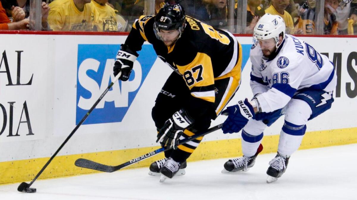 Penguins center Sidney Crosby controls the puck in front of Lightning forward Nikita Kucherov during Game 7 of their teams' playoff series on May 26.