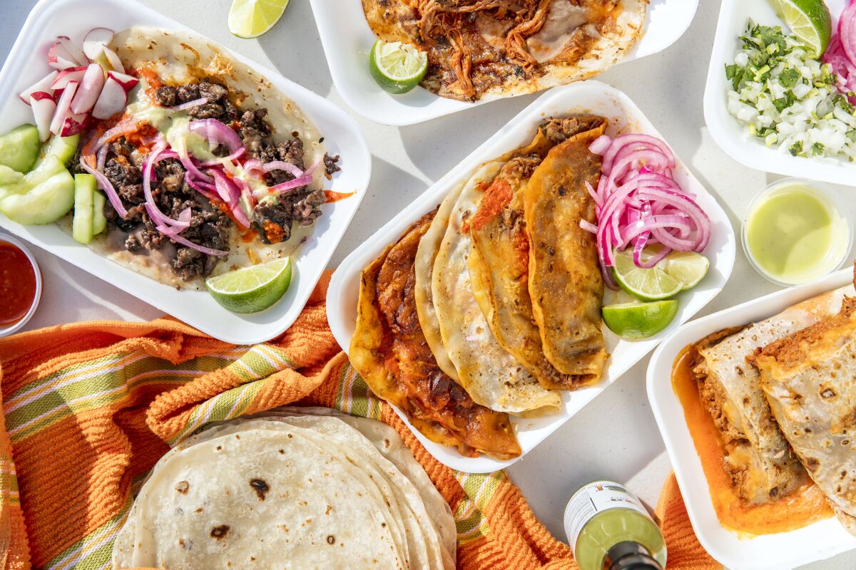 A spread of tacos at El Ruso, filled with meats including birria de res, carne asada and chile colorado.