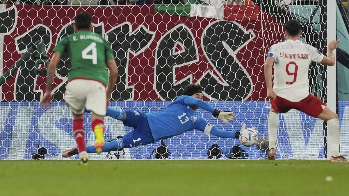 El portero de México, Memo Ochoa, detiene un penalti al polaco Robert Lewandowski.