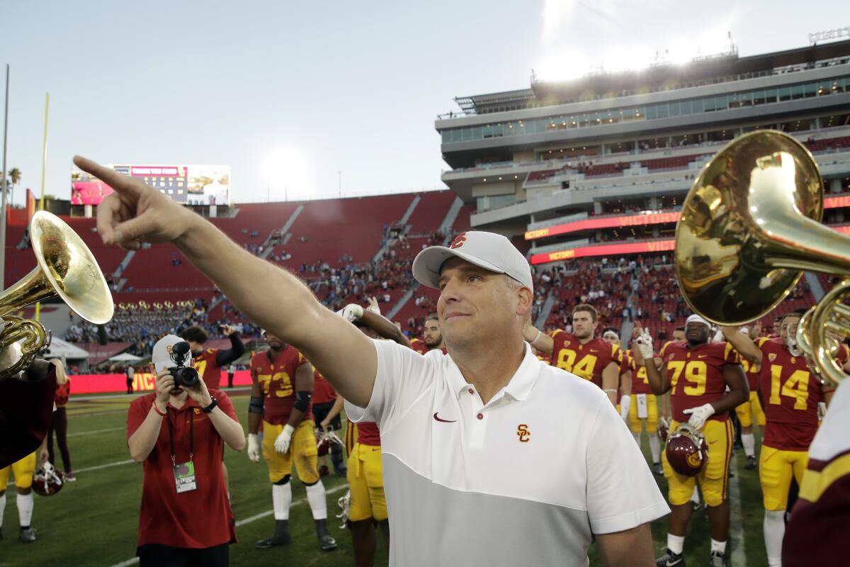 USC coach Clay Helton signals to fans after a 52-35 win over UCLA on Nov. 23, 2019, at the Coliseum.