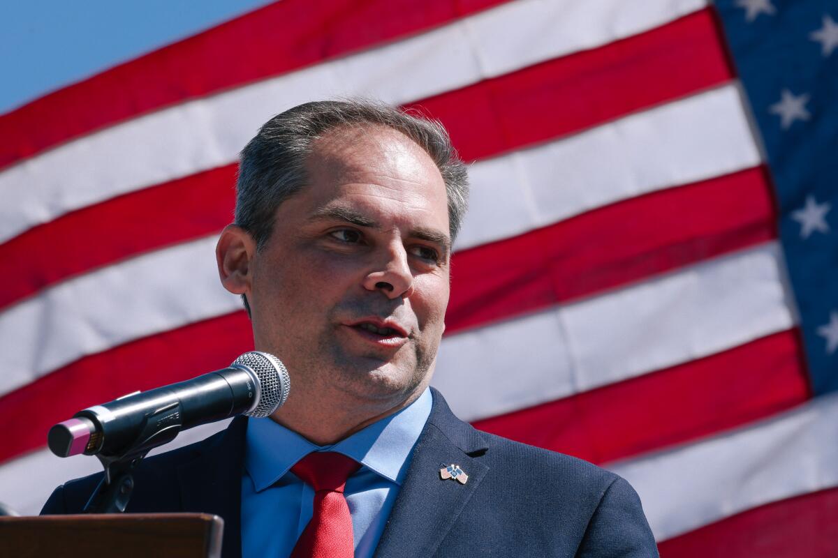 Rep. Mike Garcia speaks at a Memorial Day event with an American flag as his backdrop.