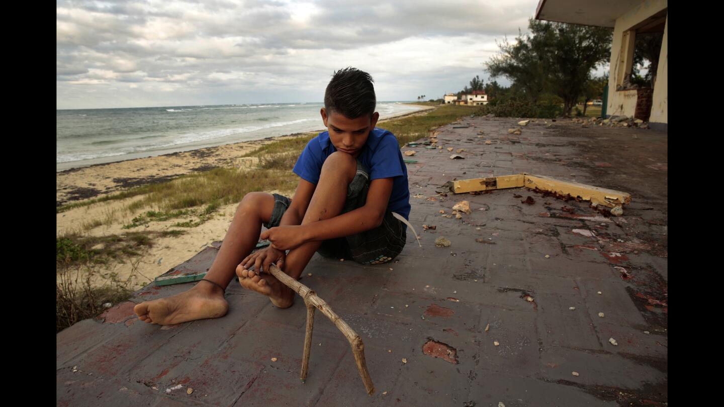 Alejandro Tellez, 14, sits near an abandoned home once owned by Americans, according to locals from the town of Guanabo, Cuba. Despite their location on the north shore of Cuba, the homes have remained vacant since the Cuban Revolution in the 1950s.