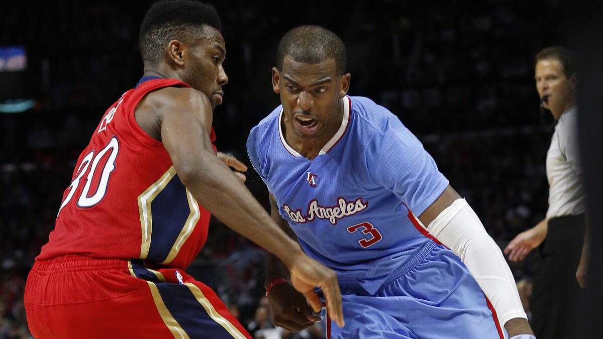 Clippers point guard Chris Paul, right, tries to drive around New Orleans Pelicans guard Norris Cole during the Clippers' 107-100 win at Staples Center on March 22, 2015.