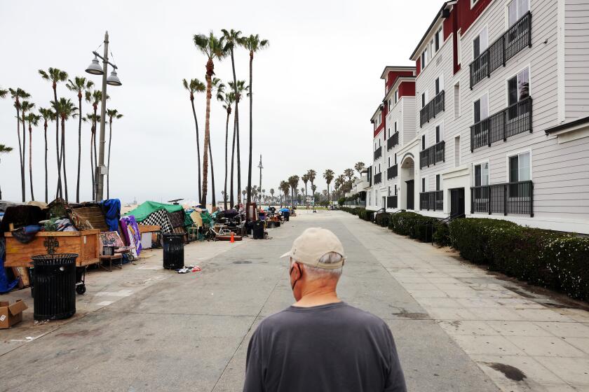 LOS ANGELES, CA - MAY 31: Arthur Kraus strolls along the boardwalk in front of his home, where he has seen the gradual transformation to a sprawling homeless encampment in Venice on Monday, May 31, 2021 in Los Angeles, CA. He and his wife have lived in the area for years and lately have avoided walking outside their home at certain hours. (Dania Maxwell / Los Angeles Times)