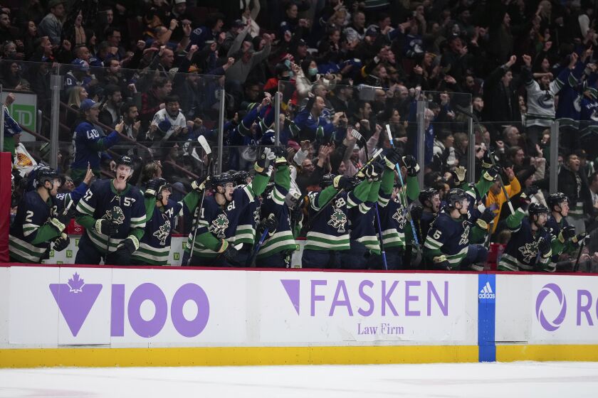 Vancouver Canucks celebrate on the bench after Bo Horvat scored against the Arizona Coyotes during overtime in an NHL hockey game Saturday, Dec. 3, 2022, in Vancouver, British Columbia. (Darryl Dyck/The Canadian Press via AP)