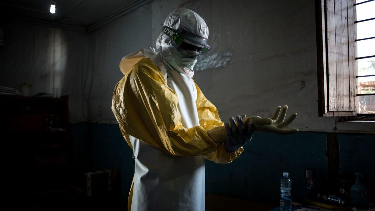 A health worker puts on his personal protective equipment before entering the so-called red zone of an Ebola treatment center in Congo.