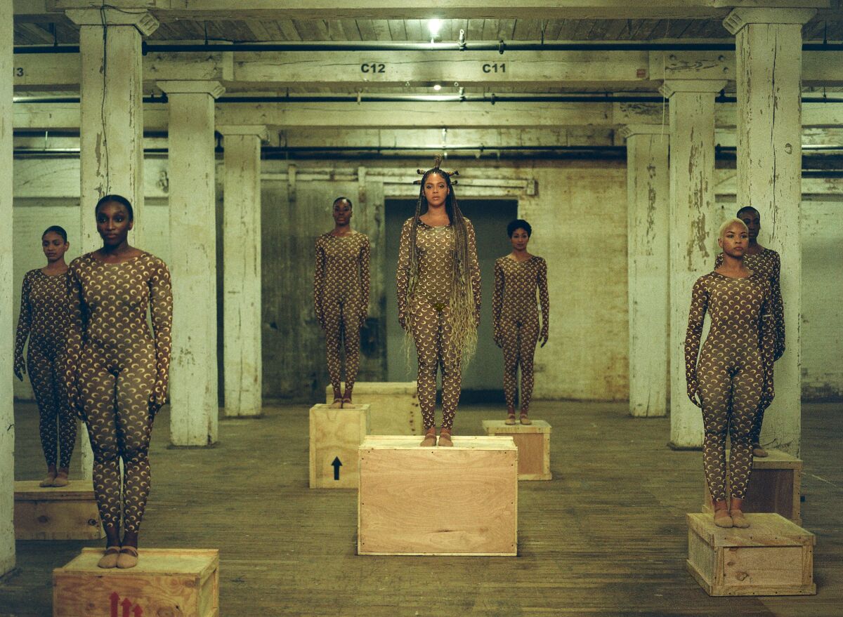 Beyoncé and six dancers clad in Marine Serre bodysuits, standing on wooden crates.