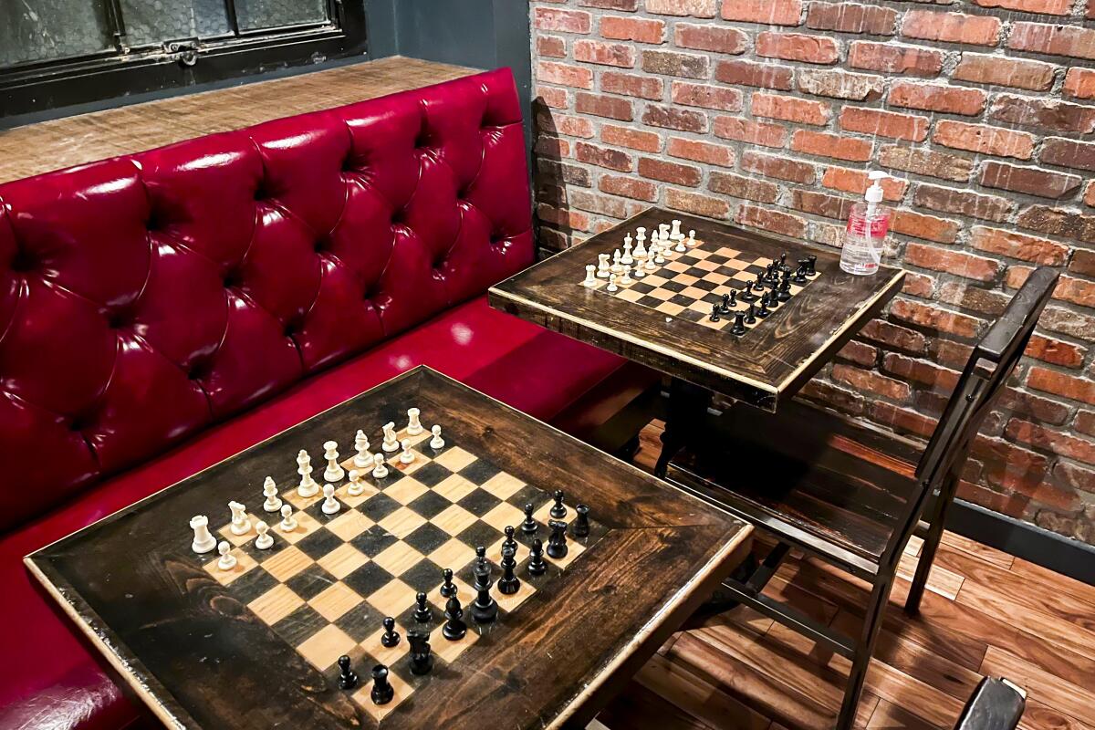 A red booth and tables inlaid with chess boards at the Rhythm Room.