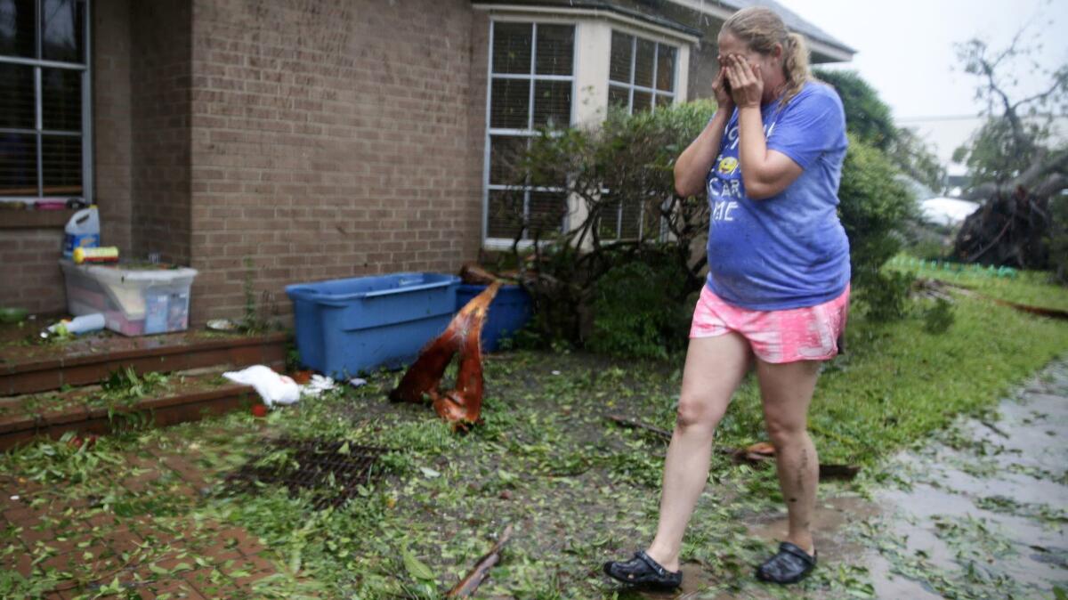 Nancy Bram, 39, heads back inside her home after surveying the damage to her frontyard in Victoria, Texas, on Saturday.