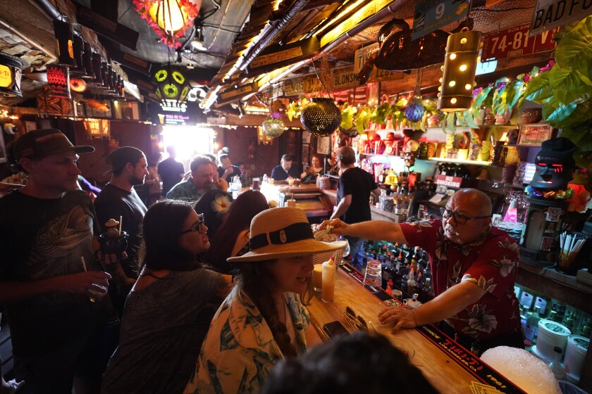 Customers drinking in a small, crowded bar