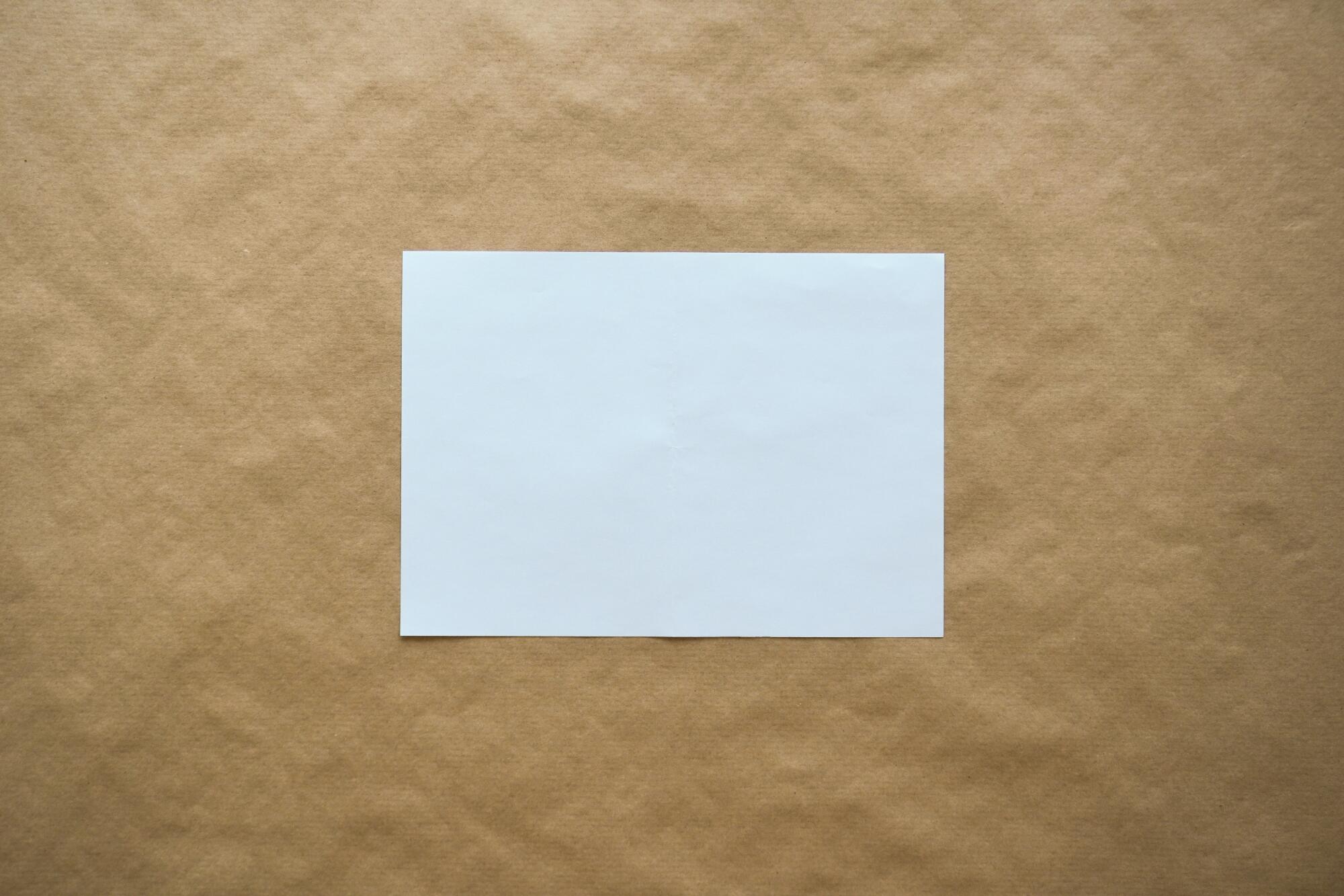 blank piece of paper on a brown paper background