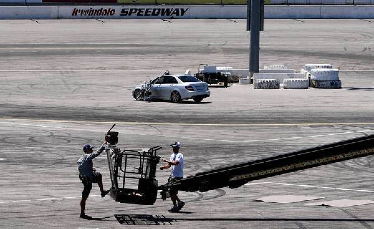 A film crew readies a camera on a boom to film a Mercedes-Benz commercial at Irwindale Speedway.